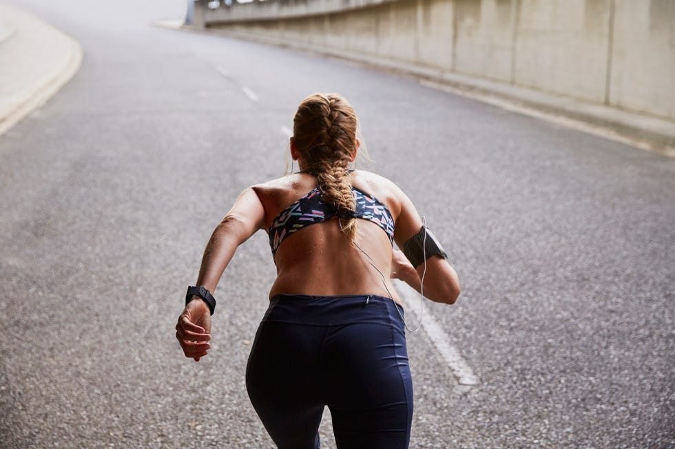 Fit female runner with mp3 player armband running on urban street