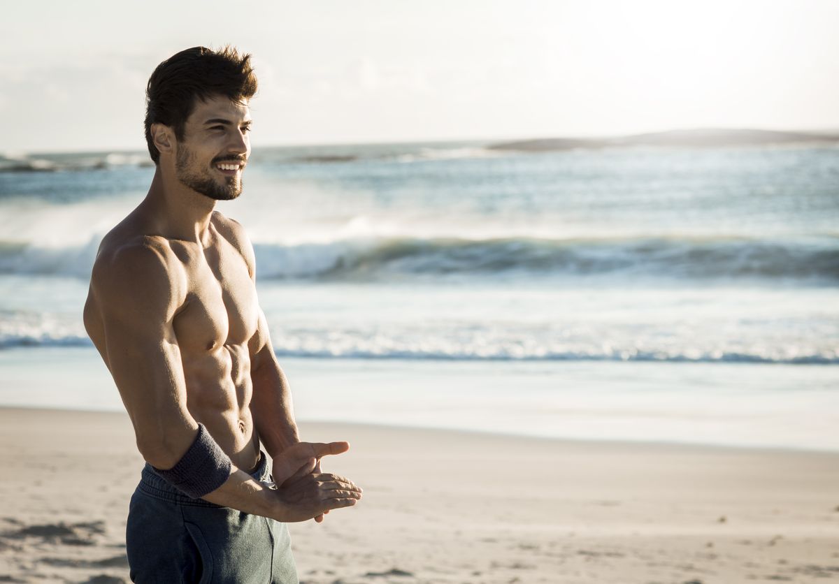 fit man relaxing on the beach
