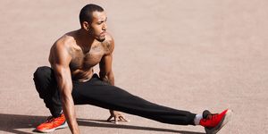 Fit shirtless black man doing stretching before workout