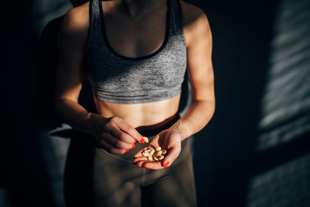 fit woman eating healthy snack after training in the gym