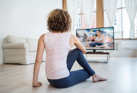 Fit woman exercising at home watching a DVD