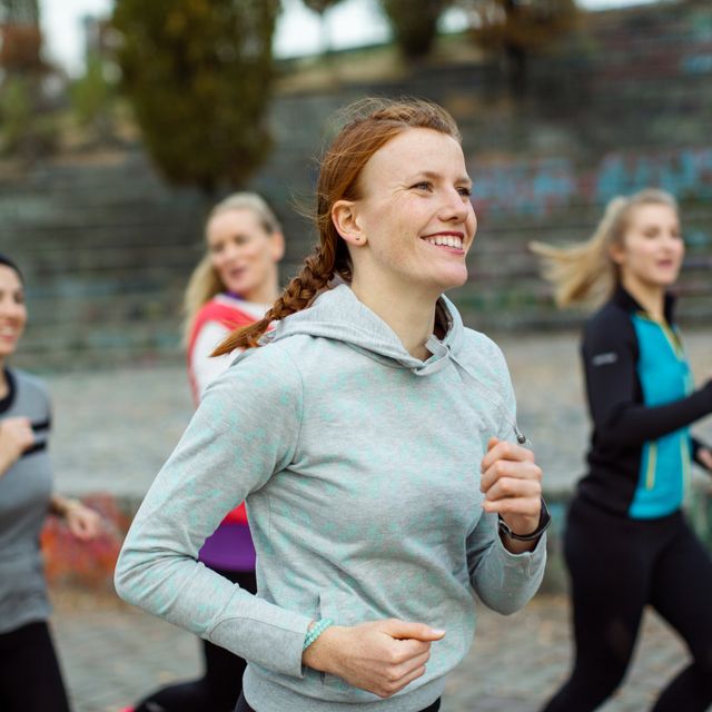 Fit woman with friends jogging in park