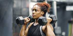 fit, young woman working out with hand weights in a fitness gym