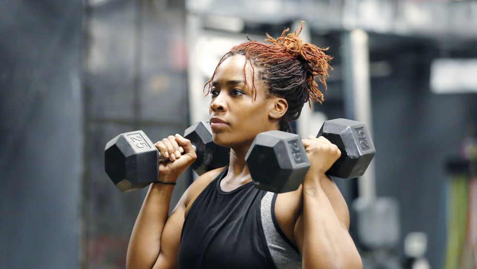 ragazza che solleva pesi in palestra