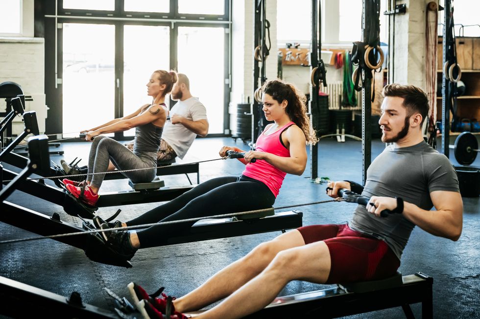 fitness enthusiasts exercising using rowing machines