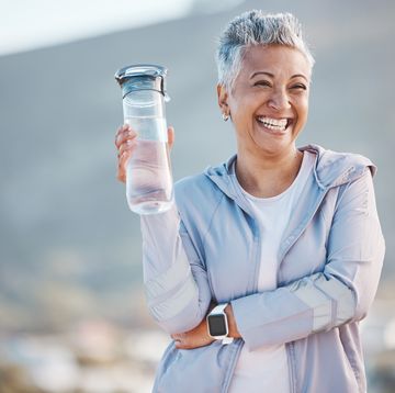 fitness, happy or old woman with water bottle in nature to start training, exercise or hiking workout in new zealand. portrait, liquid or healthy senior person smiles with pride, goals or motivation