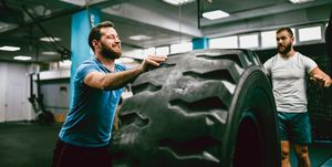 Fitness Instructor Explaining Tire Pushing Exercise to Young Male Athlete