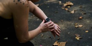a runner checks their watch while sitting down following a workout