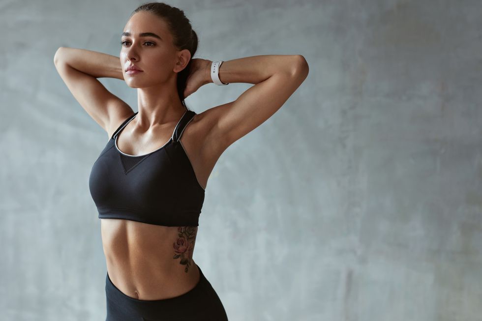 fitness woman stretching arms in stylish black sport clothes