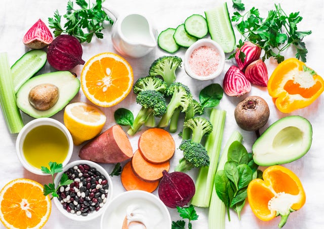 five best vitamins for beautiful skin products with vitamins a, b, c, e, k   broccoli, sweet potatoes, orange, avocado, spinach, peppers, olive oil, dairy, beets, cucumber, beens flat lay, top view