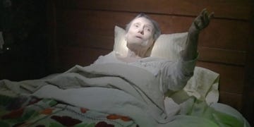 old woman lying in bed with sheets pulled up