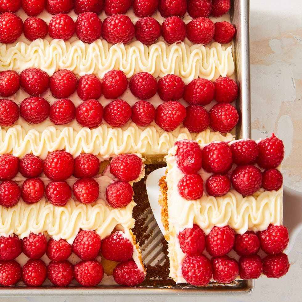 cake topped with raspberries, icing, and blueberries to create an american flag design