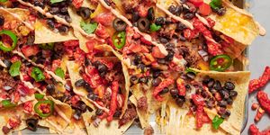 nachos topped with flaming hot cheetos, black beans, jalapenos and cilantro
