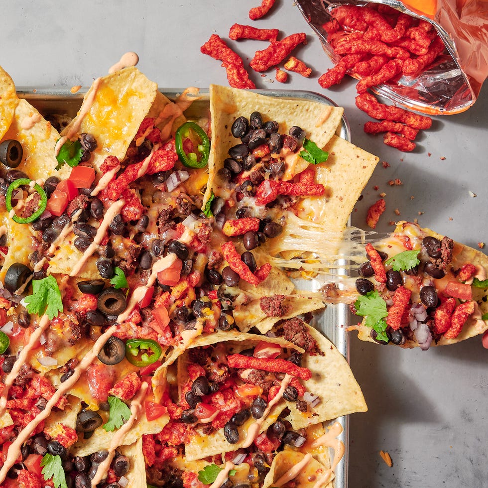 nachos topped with flaming hot cheetos, black beans, jalapenos and cilantro