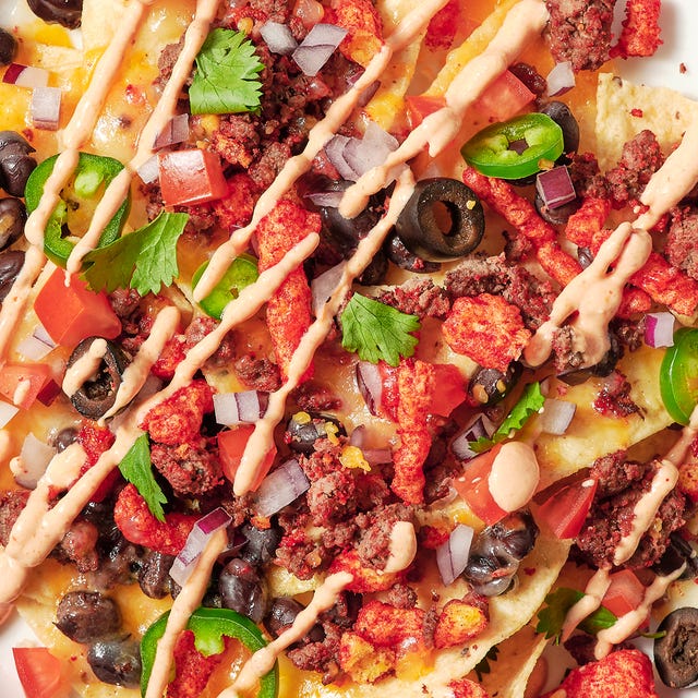 nachos topped with flaming hot cheetos, black beans, jalapenos and cilantro