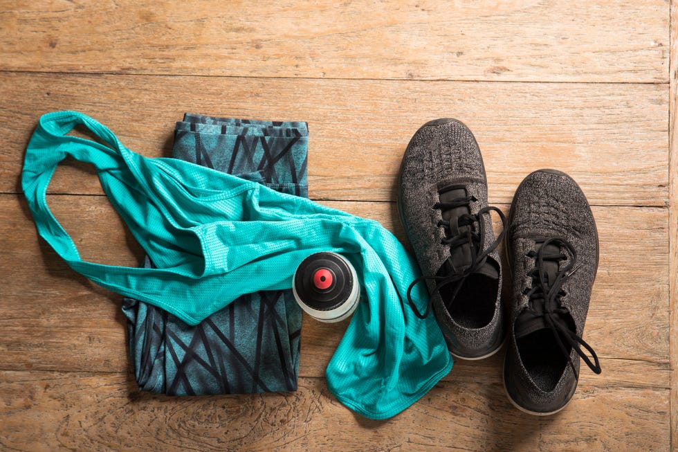 Flat Lay image of sports clothes and shoes on a wooden floor.