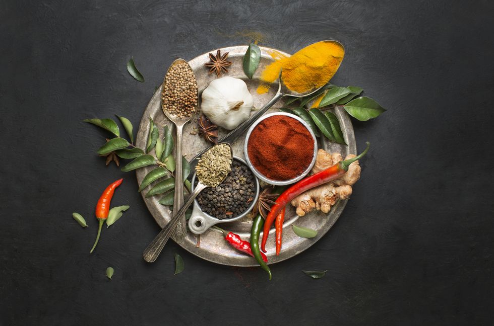 flat lay overhead view herb and spices on textured black background