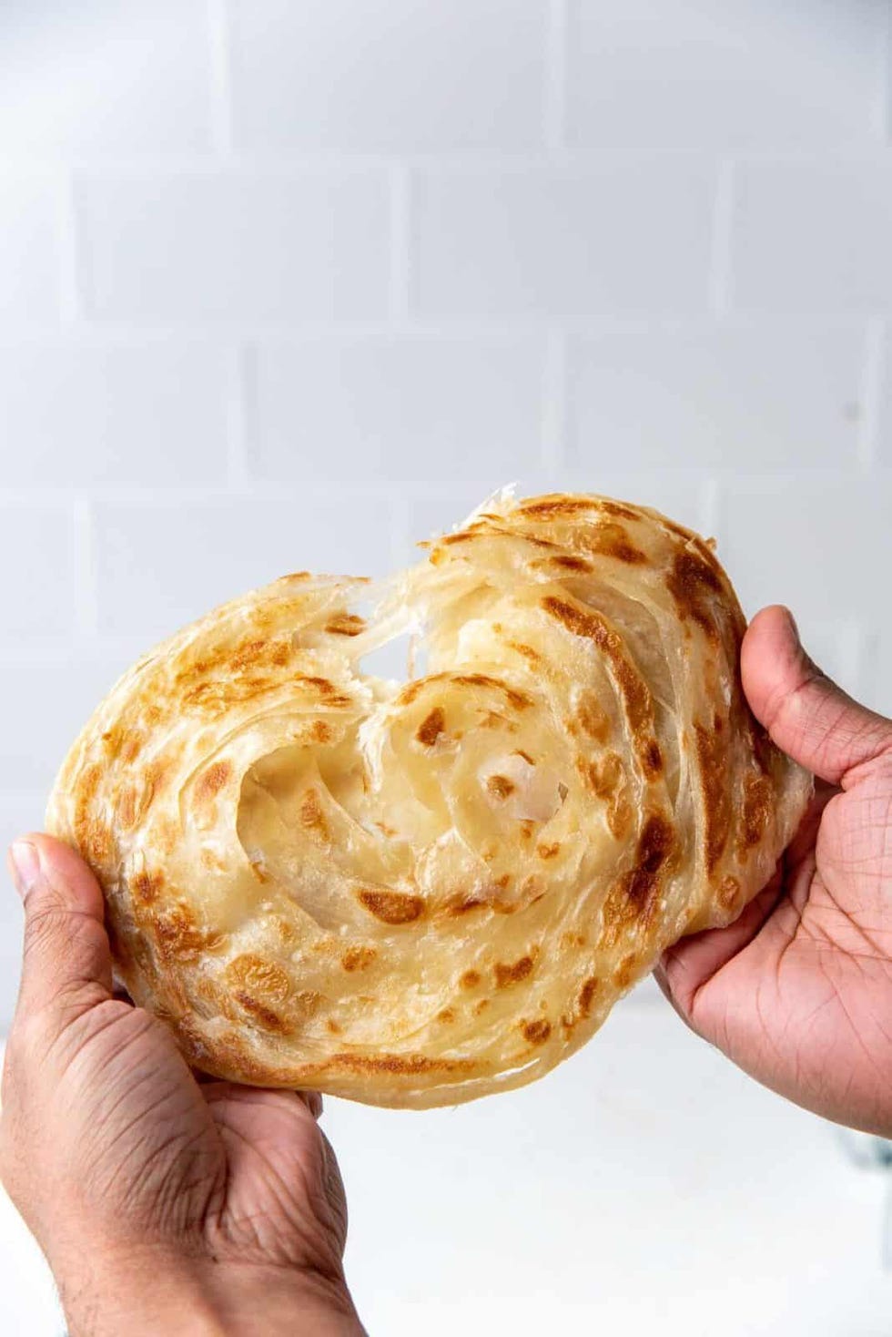 flaky roti canai being pulled apart