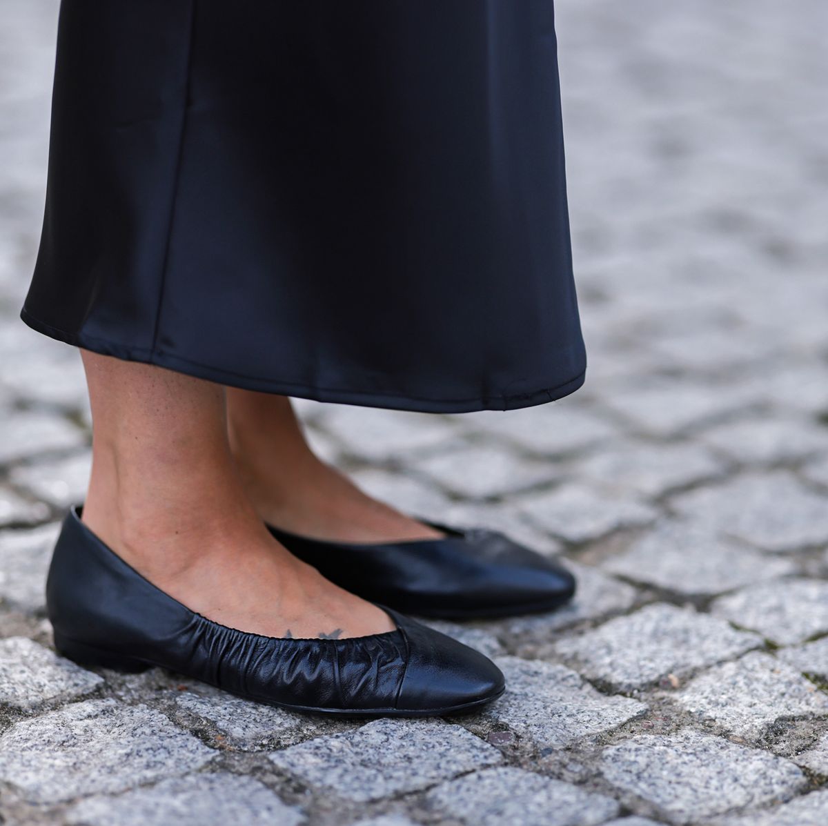 a person's legs in black shoes