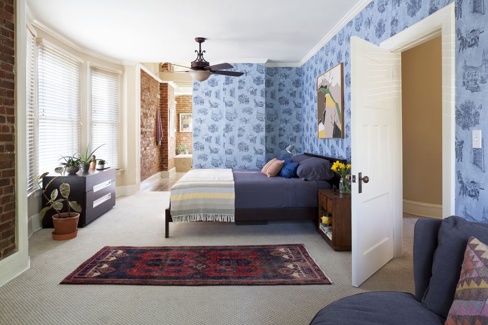 bedroom with blue wallpaper and brick walls
