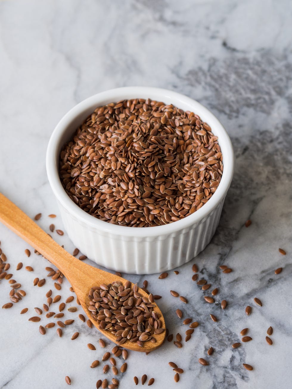 Flax seeds in ramekin on marble board