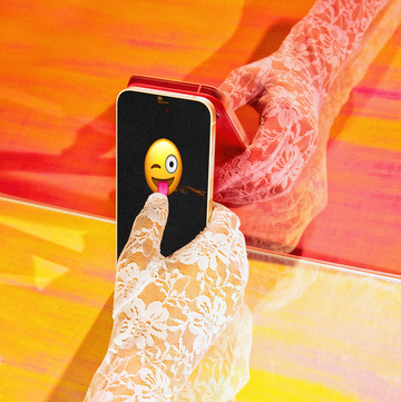 a lace gloved hand holding a phone with a flirty emoji on the screen