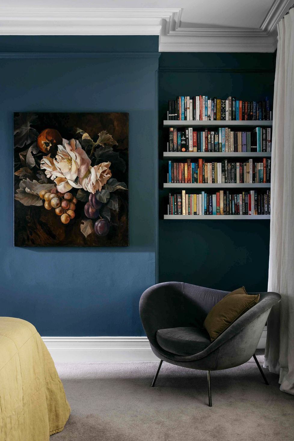 bedroom with dark blue walls and floating shelves