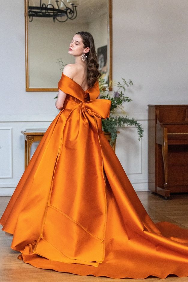 グランマニエ 銀座の深みのあるテラコッタカラーのカラードレスを着たモデルの写真。