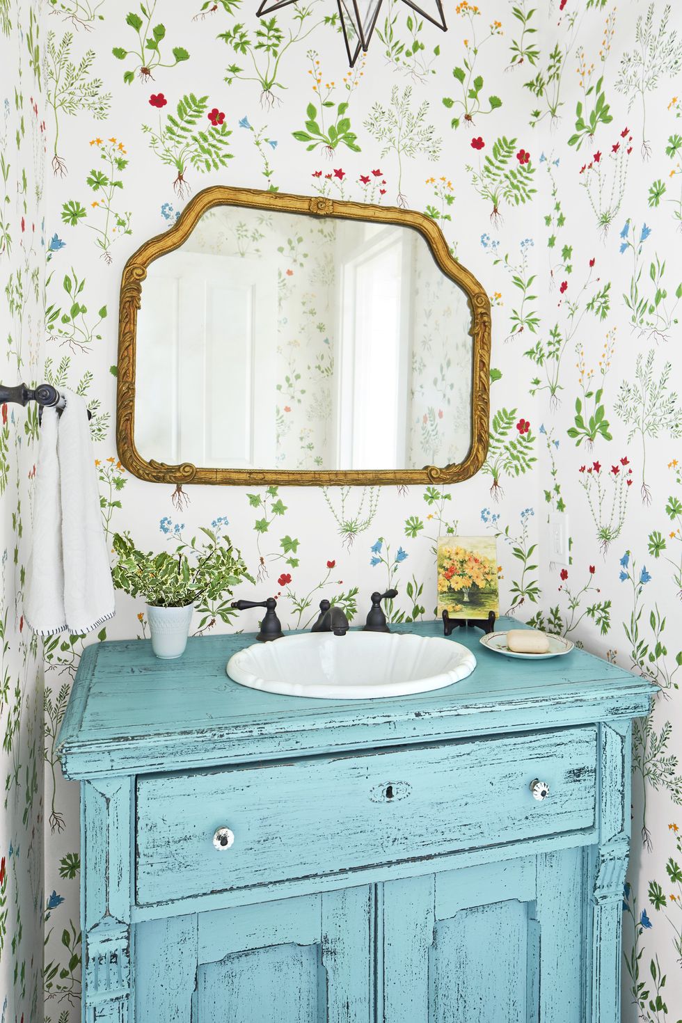 powder bath with floral wallpaper and a bright blue reclaimed vanity