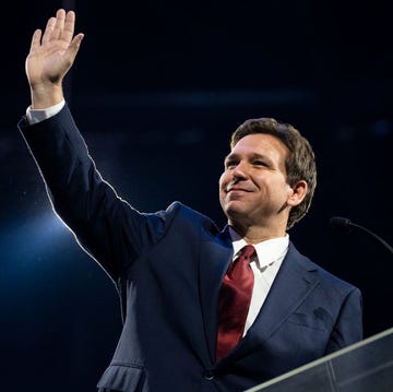 Florida Gov. Ron DeSantis speaks at Liberty University ron desantis waving to an audience with his right hand as he stands at a podium