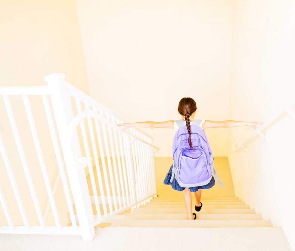 How to get the kids to school on time - girl with backpack walking down stairs at home