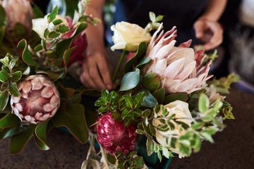 florist making a flower arrangement with proteas