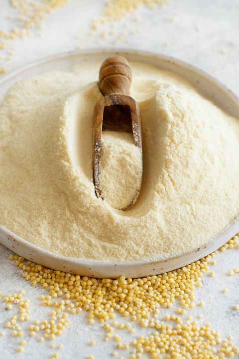 hulled millet flour on a ceramic plate and grain close up