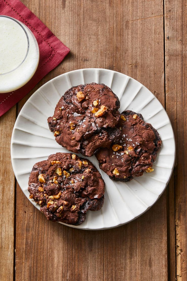 flourless chocolate walnut cookies on a white plate on a wooden table