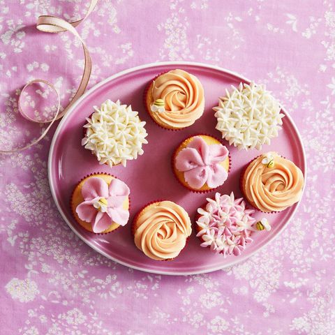 peach and purple flower cupcakes on a pink plate