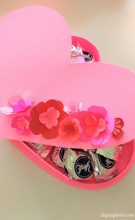 heartshaped box filled with candies decorated with paper flowers