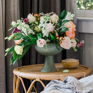 flowers in vase next to bed