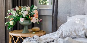 flowers in vase next to bed