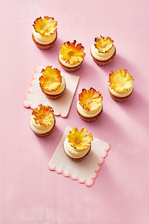 carrot pineapple cupcakes on a pink table