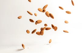 flying almond nuts on white background