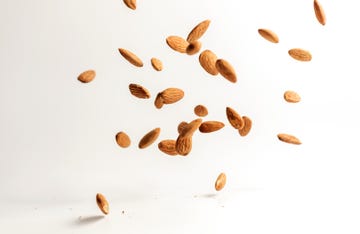 flying almond nuts on white background