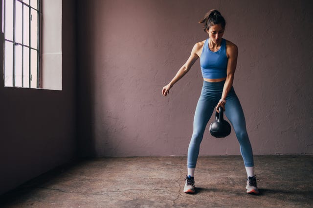 https://hips.hearstapps.com/hmg-prod/images/focused-woman-exercising-with-kettlebell-in-a-gym-royalty-free-image-1730757257.jpg?crop=1xw:0.74965xh;center,top&resize=640:*