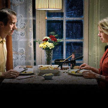 a man and a woman sitting at a table with food