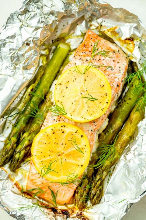 salmon and asparagus in a foil pack topped with lemon, dill, and pepper
