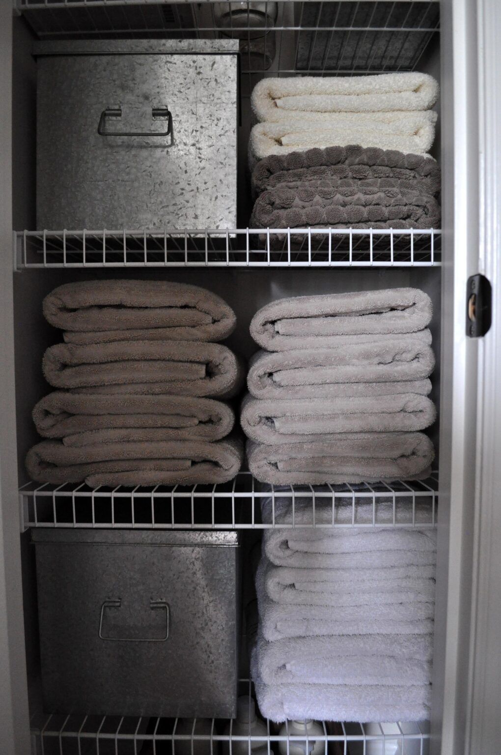 Linen closet / bathroom closet organization for a family. Stackable bins  and a rack on the door help maximize storage and keep everyone's…