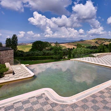 a pool with a view of a town and hills in the background