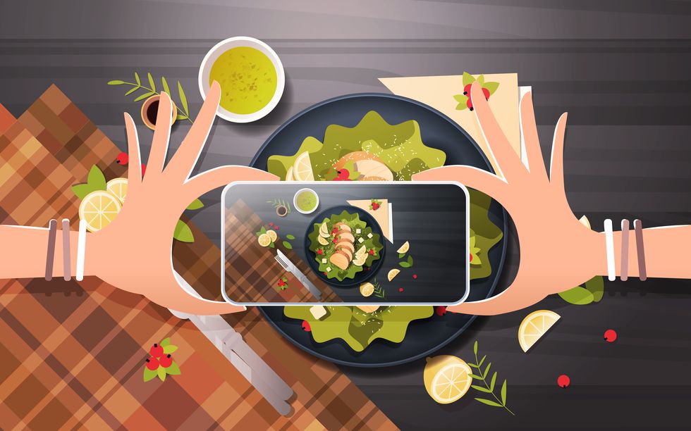 food blogger taking mobile photo of fresh vegetable salad with chicken and sauce in black bowl top angle view smartphone screen social network activity concept horizontal