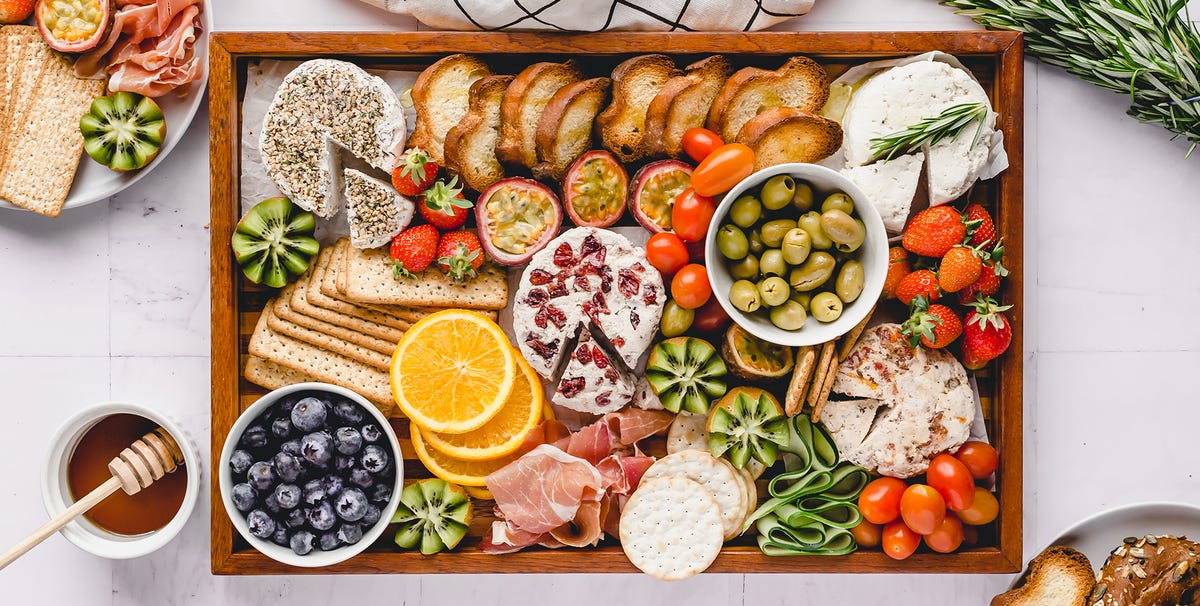 cheese fruit cracker olives on wooden tray