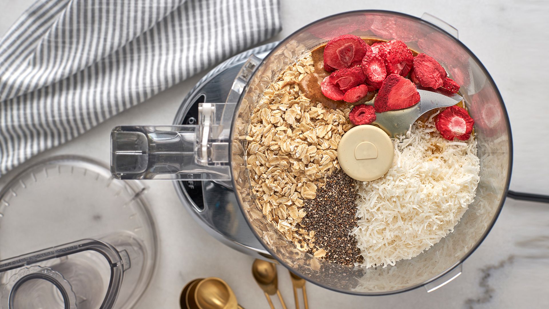 food processor with oats, strawberries, chia seeds and coconut