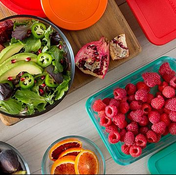 food storage containers with salad and cut fruit in them